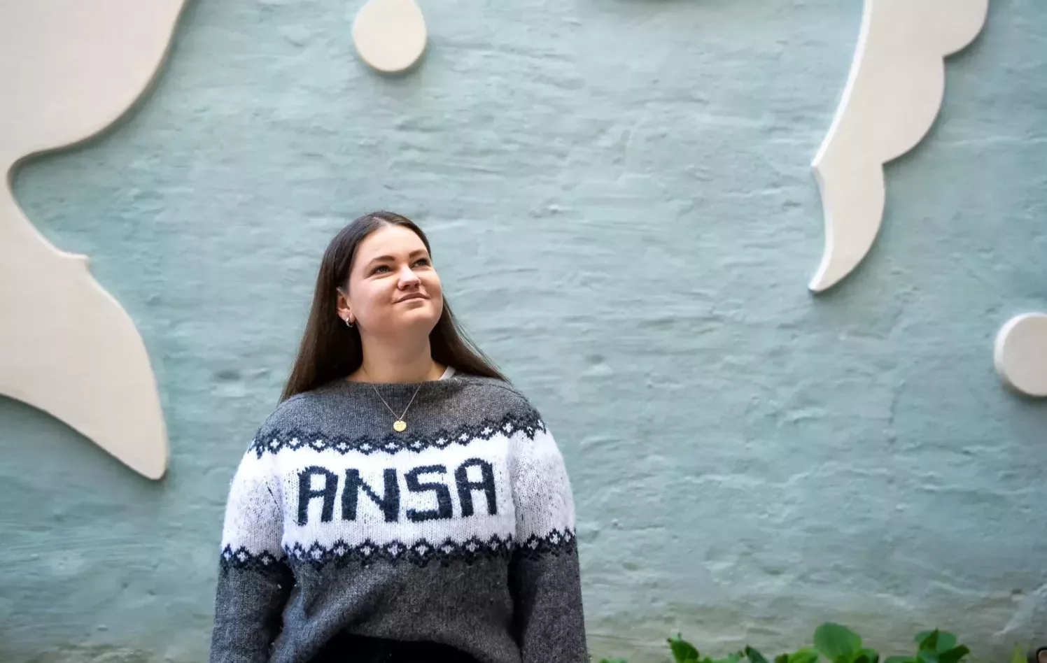 Anna Handal Hellesnes med ANSA-genser foran blå vegg